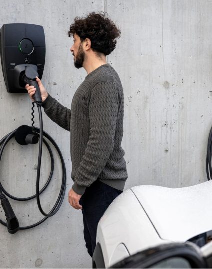 Mies lataa sähköautoa